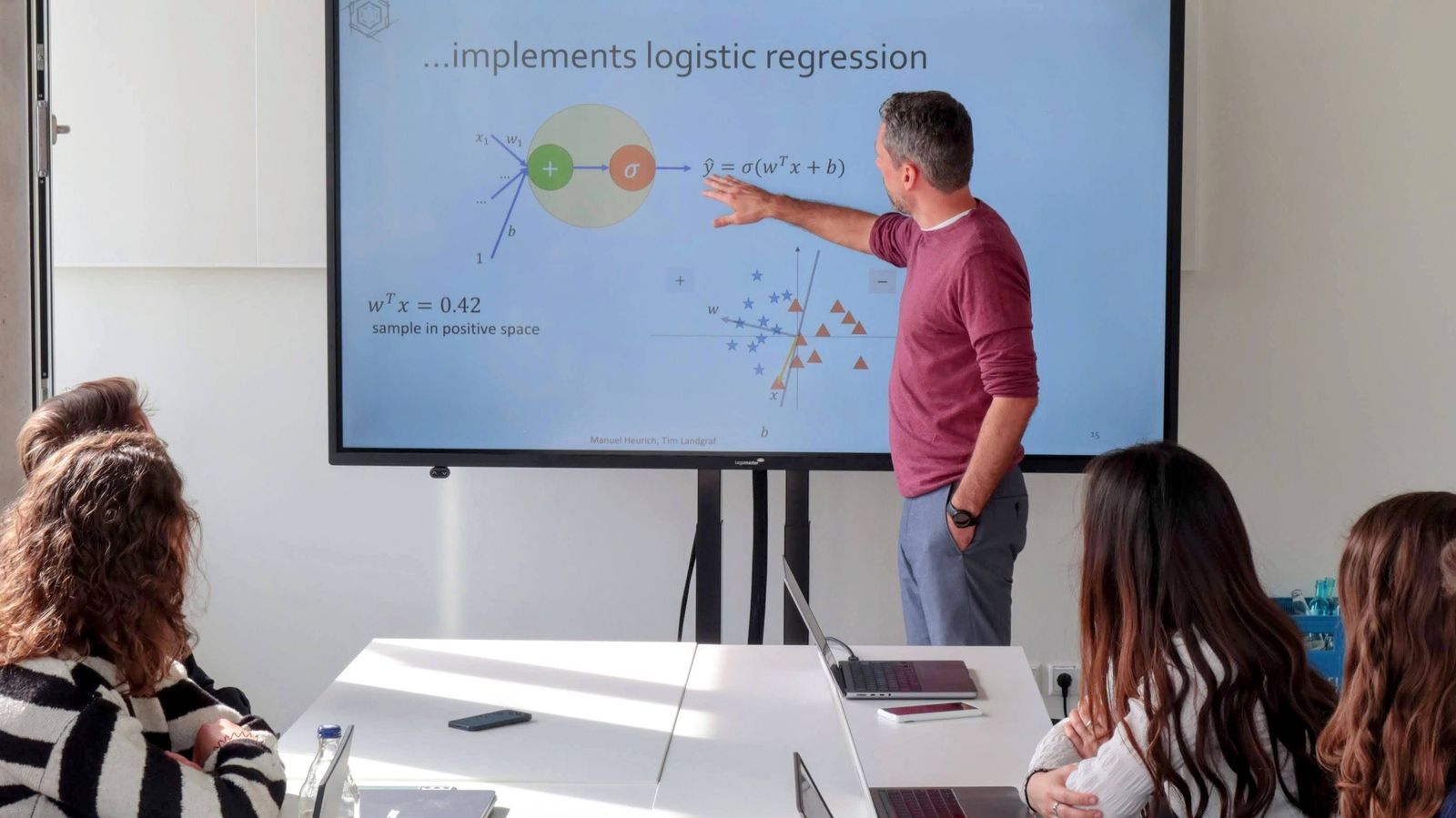 Prof. Dr. Tim Landgraf erklärt logistische Regression an einem Bildschirm vor einer kleinen Gruppe